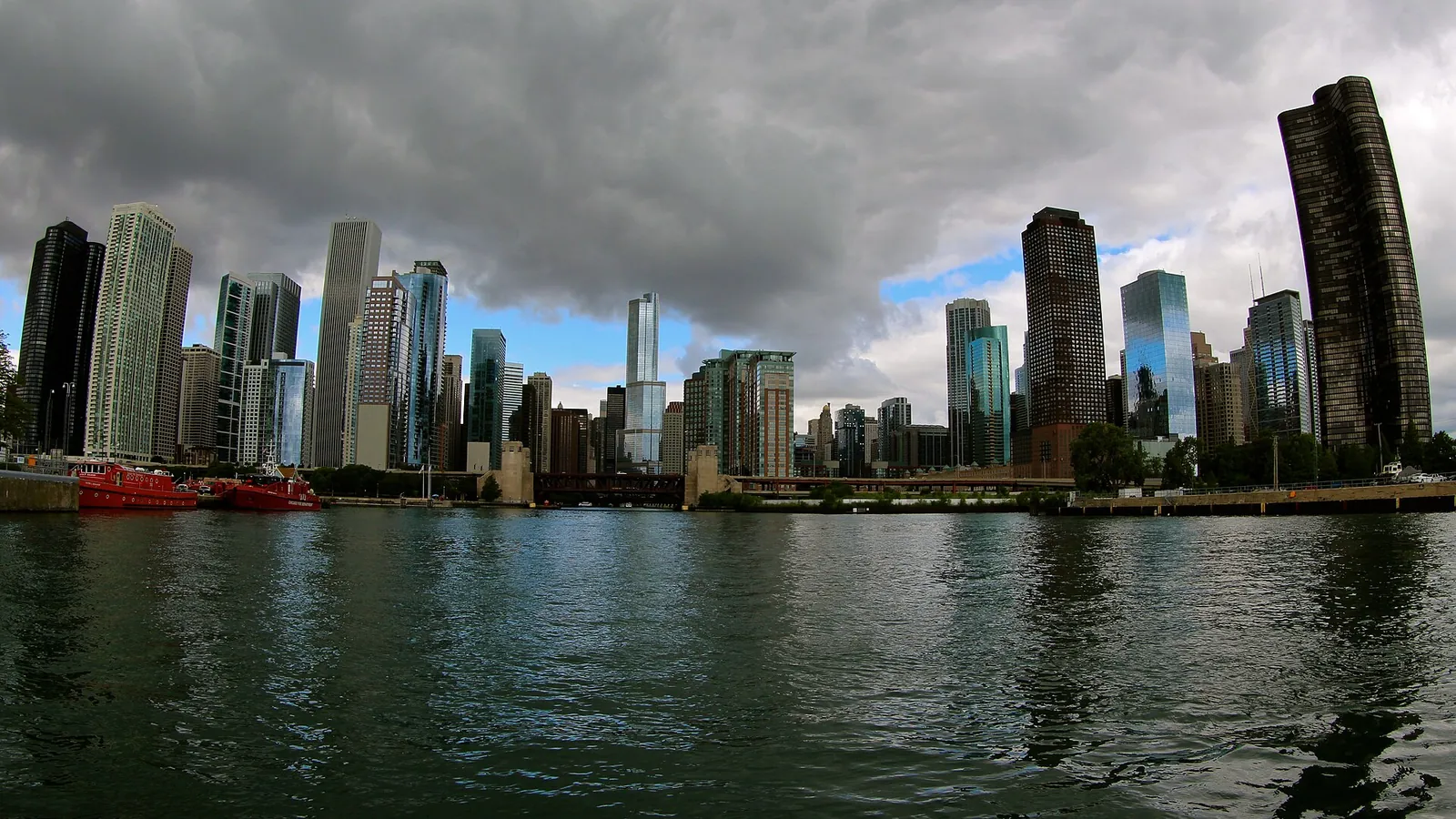 A tour boat on the Chicago River between the glass and stone towers of the downtown Loop