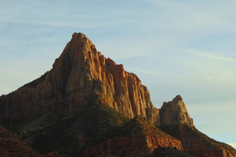 The Watchman peak rising above the Virgin River in Zion Canyon at sunset