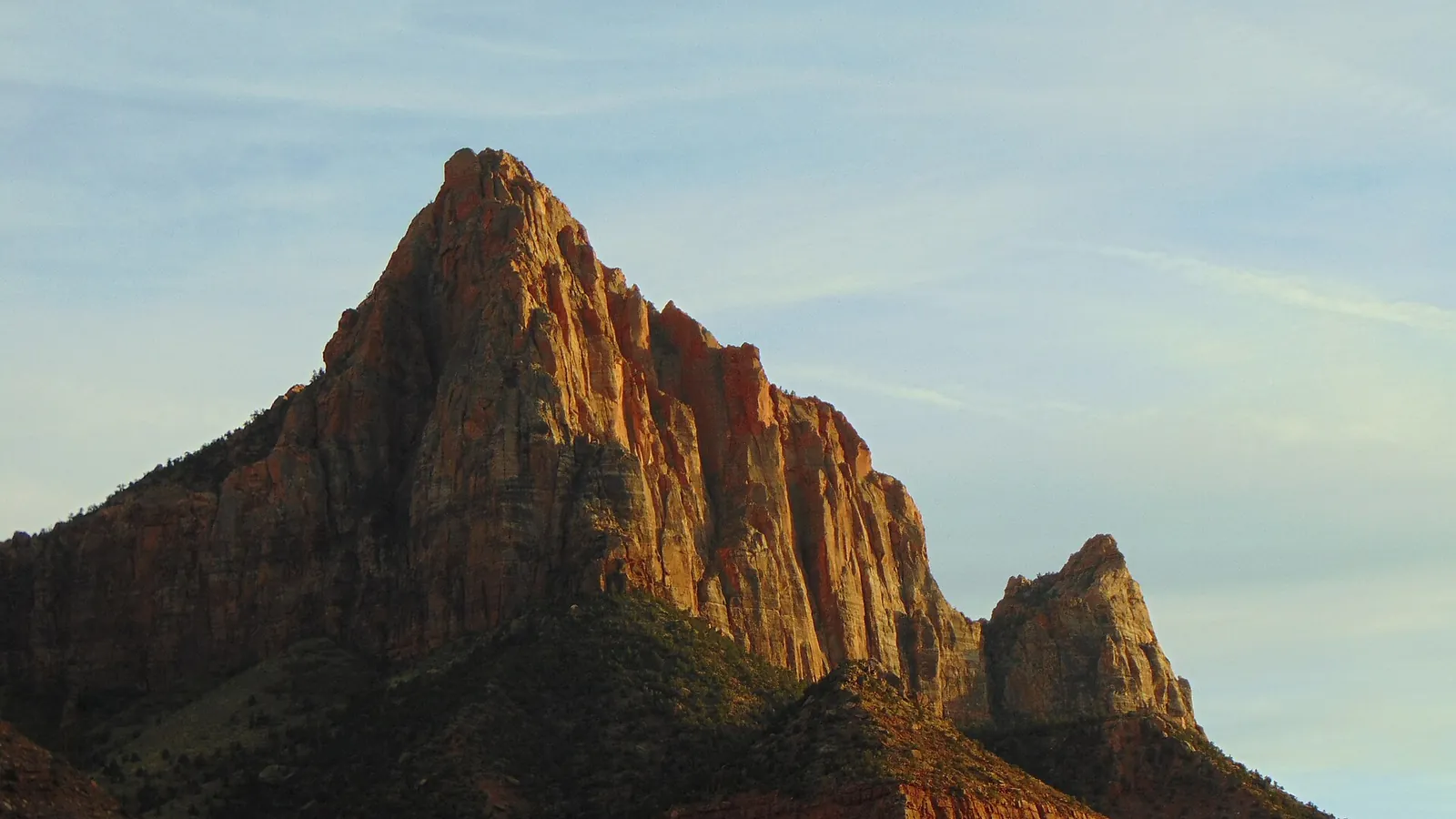 The Watchman peak rising above the Virgin River in Zion Canyon at sunset