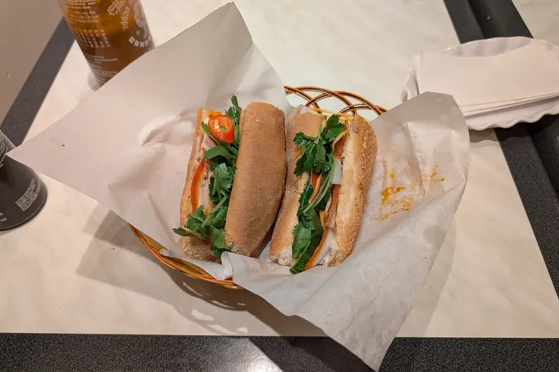 A Vietnamese banh mi baguette sandwich with pork, pâté and pickled vegetables