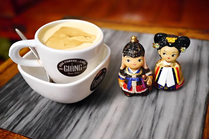 A cup of Hanoi egg coffee topped with whipped egg yolk cream